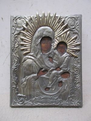 une image représentant une plaque métallique sur laquelle figure une femme tenant un enfant dans ses bras