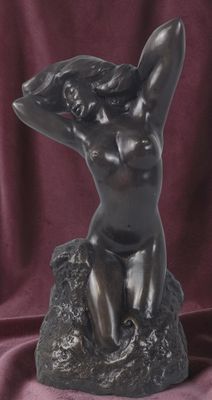 statue en bronze représentant une femme assise sur un rocher, les mains derrière la tête