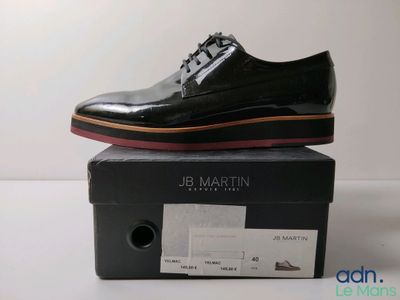 les chaussures noires sont posées sur la boîte, sur la table