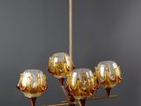 someone is holding a gold chandelier with six wine glasses on it
