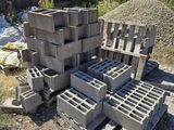 a pile of cinder blocks on the ground next to a pile of garbage