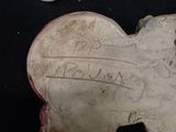 a heart shaped object with writing on it on a black surface