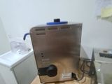 a coffee maker sitting on a wooden table in a kitchen