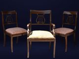 trois chaises en bois avec des coussins rembourrés beiges sur fond noir