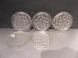 quatre sous-verres en verre posés les uns à côté des autres sur une table