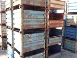 many crates stacked on top of each other in the dirt