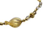 an image of a gold and silver bracelet with a glass bead