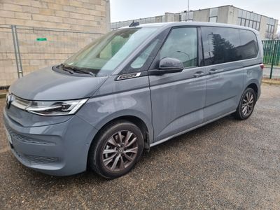 La camionnette grise est garée sur un parking près d'un immeuble.