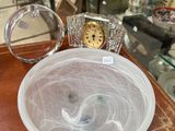 a glass bowl on a table with a clock in it