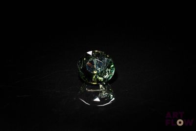 gros plan d'un diamant vert sur une surface noire