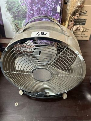 un ventilateur posé sur une table dans une pièce