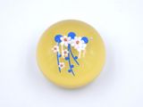 une boule jaune ornée de fleurs bleues et blanches