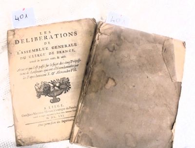 deux vieux livres posés sur une nappe blanche