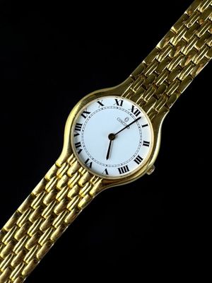 an image of a gold watch with roman numerals on a black background