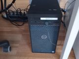 a black computer on a hard wood floor next to a wall
