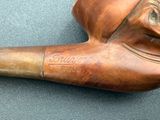 a wooden pipe with a carved face on it