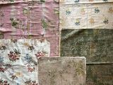 de nombreux types de courtepointes exposés dans une pièce