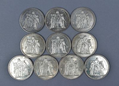 six different types of silver coins on a blue surface