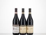 three bottles of red wine are lined up on a table