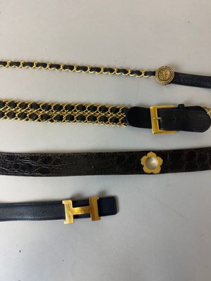 trois ceintures avec des chaînes en or et une ceinture noire avec une boucle en or