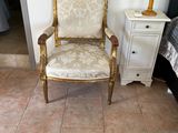une chaise dans un coin d'une pièce où se trouve un miroir accroché au mur