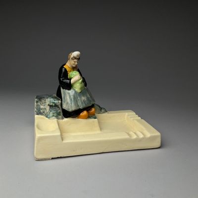 a figurine of a woman holding a baby on a tray
