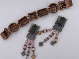 two pieces of jewelry sitting on top of a white table