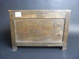 an old wooden box with a label on it sitting on a black surface