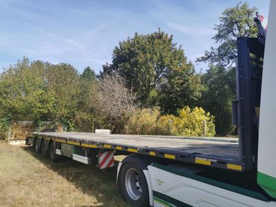 un gros camion à plateau garé dans l'herbe