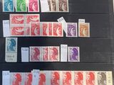 some of the stamps on display in a glass case are of different shapes and sizes