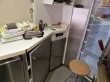 une petite cuisine équipée d'un réfrigérateur et d'un plan de travail