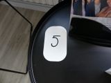 une table noire sur laquelle se trouvent une souris blanche et un magazine