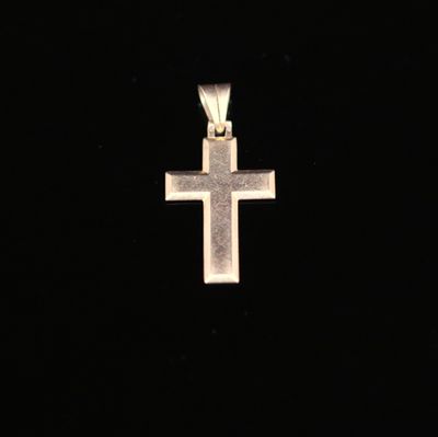 un pendentif en forme de croix en argent sur fond noir