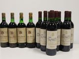 six bottles of wine are lined up on a white surface