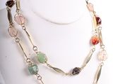 collier composé de pierres multicolores et de chaînes dorées, porté par un mannequin blanc