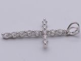 a silver cross pendant on a white background