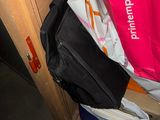 a pink bag sitting on top of a pile of bags