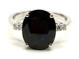 un gros plan d'une bague sertie d'une pierre noire et de diamants