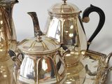 a silver tea set on a silver tray on a table