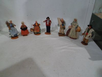 seven figurines of people dressed in traditional clothing