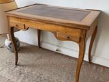 a small wooden table with a glass top on the floor