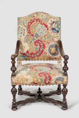 un fauteuil au revêtement richement orné, dont le dossier est recouvert d'un tissu à motifs floraux