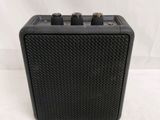 a close up of a black amplifier sitting on top of a white surface