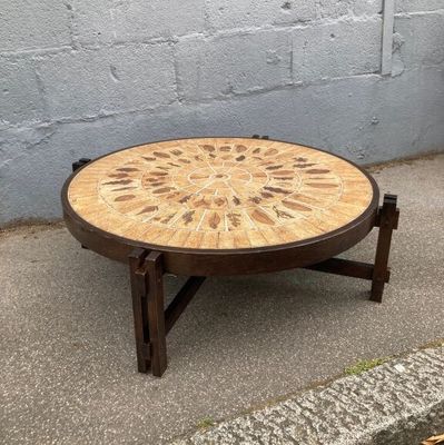 une table en bois dont le plateau est orné d'un motif circulaire