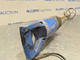 a blue electric drill on the floor in front of a wall