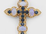 un pendentif en forme de croix en or 18 carats orné de pierres bleues et blanches