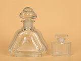 a small glass bottle with a small glass bottle next to it