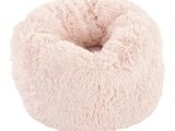 un panier pour chien en forme de beignet rose sur fond blanc