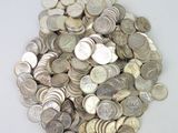 un tas d'argent et de pièces d'argent posés sur une surface blanche