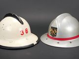 two firemen hats sitting next to each other on a table